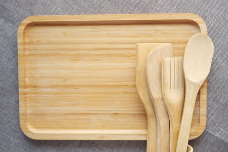 wooden cutlery fork and spoon on a chopping board on table