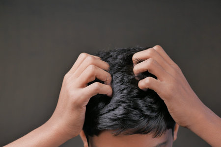 teenage boy Scratching Head Against black background .