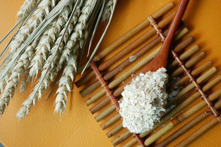 Close up of roasted oats flakes on spoon on table