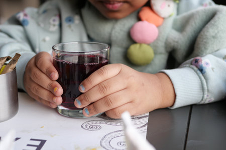 child holding a glass of soft drinksの写真素材