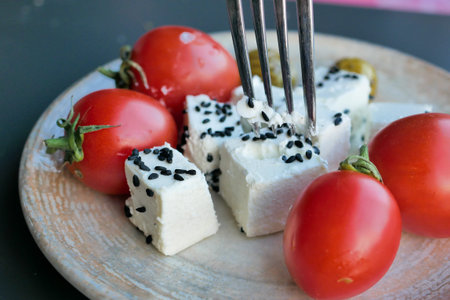 greek feta cubes with tomato diced soft cheese on plateの写真素材