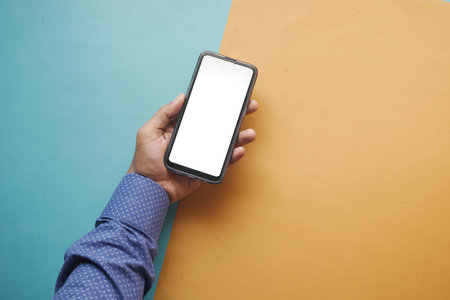 top view of young man hand using smart phone with white screen