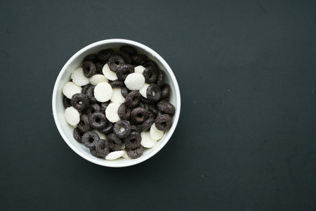 chocolate corn flakes in a bowl on black backgroundの写真素材
