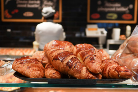 fresh baked croissant piled up on table against cafe backgroundの写真素材