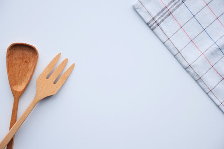 wooden cutlery fork and spoon with table cloth on white backgroundの写真素材