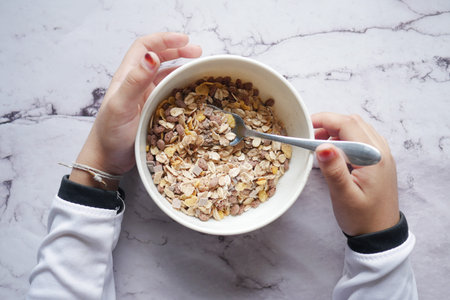 top view of child hand eating cereal breakfast