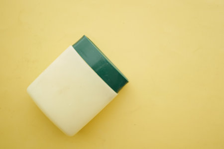 top view of petroleum jelly in a container on yellow backgroundの写真素材