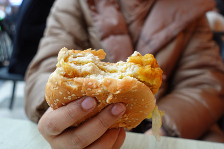hand holding beef burger on table close upの写真素材