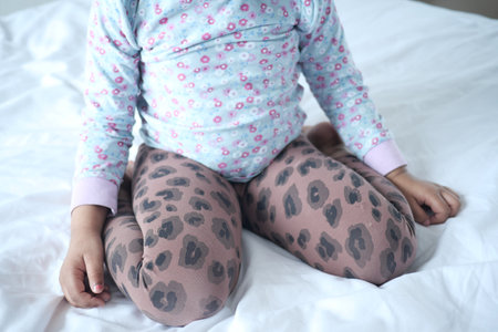 child sitting W posture on bed, bad sitting posture conceptの写真素材