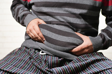 mans hand holding excessive belly fat, overweight conceptの写真素材