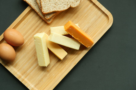 Cheese cubes green, yellow and red color on chopping boardの写真素材