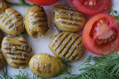 Turkish Grilled olives with olive and tomato on plateの写真素材