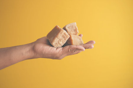 Jaggery traditional cane sugar cube on hand