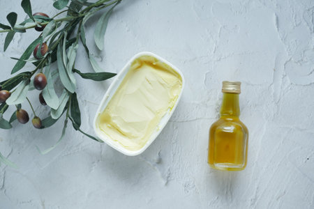 fresh butter in a container with bread on white backgroundの写真素材
