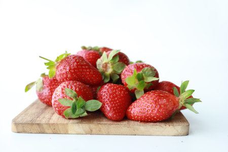 Ripe Red Strawberries on wooden board on tableの写真素材