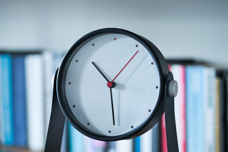 simple modern clock on a book shelf .の写真素材