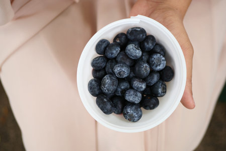 women holding a bowl of blue berryの写真素材