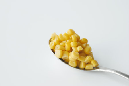 Sweet corns on a spoon on white backgroundの写真素材