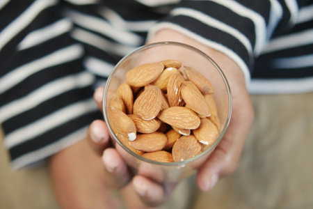 close up of almond nuts on mans handの写真素材