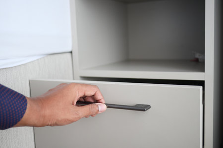 mans hand open drawer wooden in cabinetの写真素材