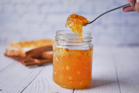orange fruit jelly in a jar on tableの写真素材