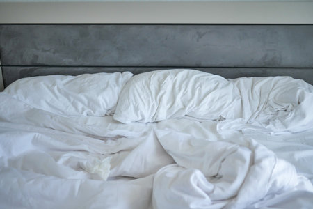 messy white bed in early morning , messy bed after waking upの写真素材