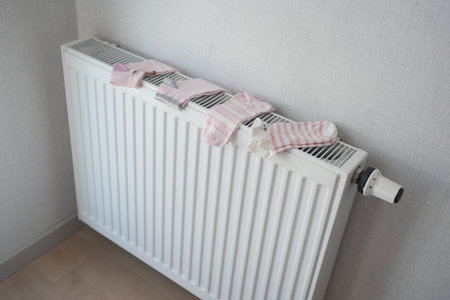 child sock drying on heating radiator,の写真素材