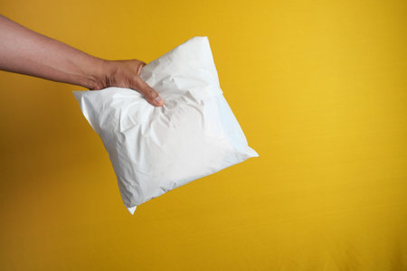 holding white color paper bubble envelope..