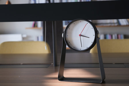 simple modern clock on a book shelf .