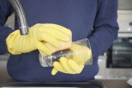 hand in gloves washing a glassの写真素材