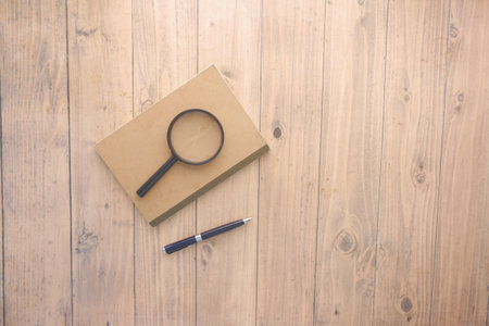open book and magnifying glass on table.の写真素材