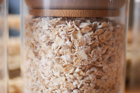 roasted oats flakes in a glass jar on tableの写真素材