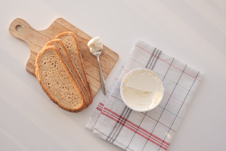 Slice of bread and cream cheese on white background.の写真素材