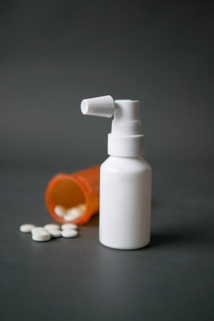 ear spray to remove earwax and medical pills on table