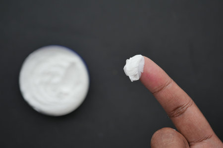 man applying beauty cream onto skin