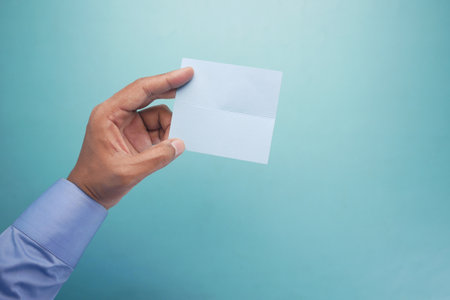 hand of man holding blue color paper card .の写真素材