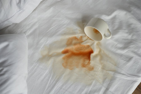 cup of coffee spilled white bedの写真素材