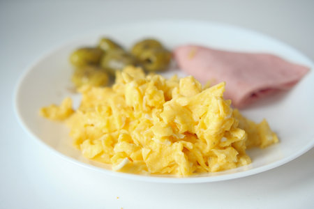 morning breakfast with Scrambled eggs on a bread on white plateの写真素材