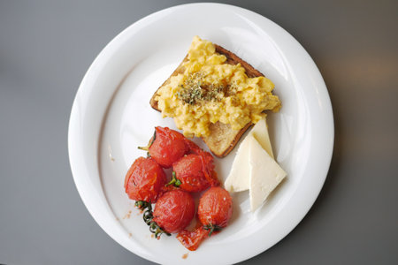 morning breakfast with Scrambled eggs on a bread on white plateの写真素材