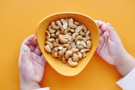 child eating cashew nuts on tableの写真素材