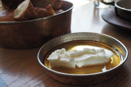 butter cream and honey in a bowl on table .