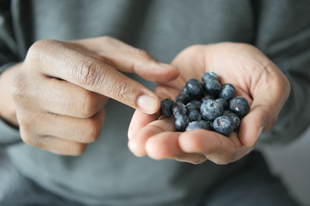 men hand pick fresh blue berryの写真素材