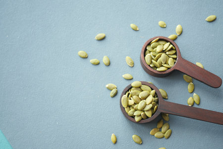 Pumpkin seeds in wooden spoon on tableの写真素材