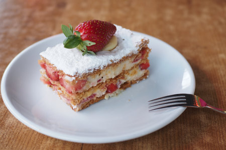 strawberry cream chocolate and cream cake on a plate on tableの写真素材
