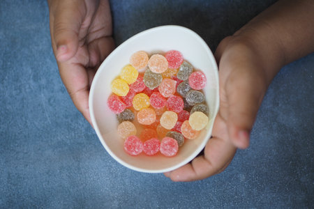 child holding a bowl of colorful candy sweet jelly iの写真素材