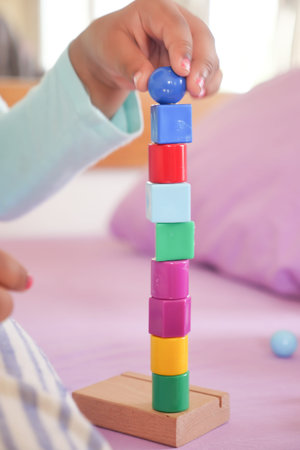 child hand playing with pyramid toy