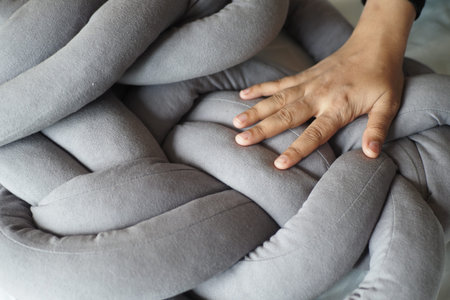 women hand over a gray color pillow on white bed