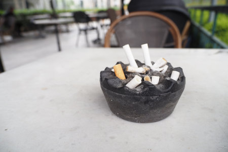 Close up burning cigarette in ashtray on tableの写真素材
