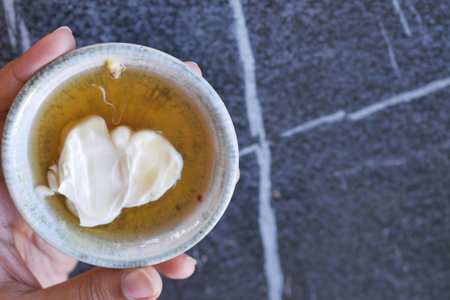 butter cream and honey in a bowl on table .の写真素材