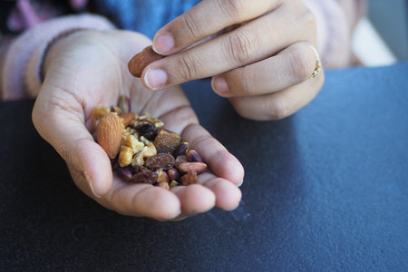 women hand pick mixed nuts